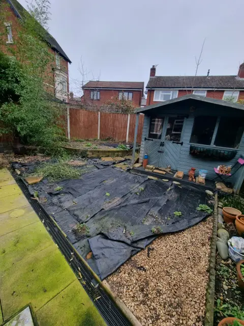 Rear garden covered in weed membrane and debris before the gravel was laid