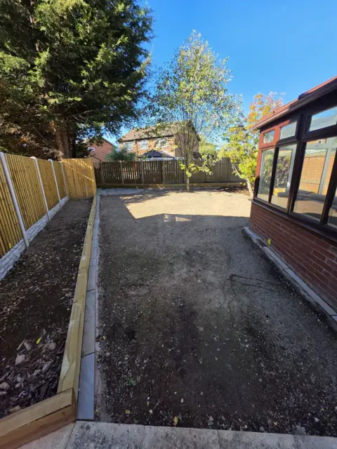 Bare levelled soil in a rear garden before new turf was laid