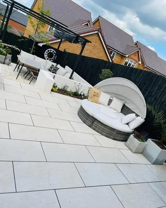 Light porcelain patio with garden seating completed by The Green Team