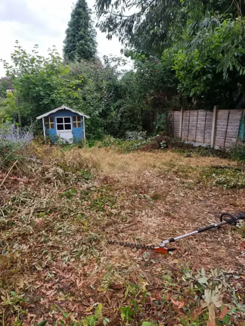 Overgrown rear garden before clearance